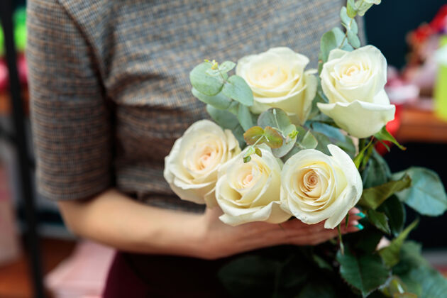颜色女花匠手里拿着一束白玫瑰花卉优雅花店
