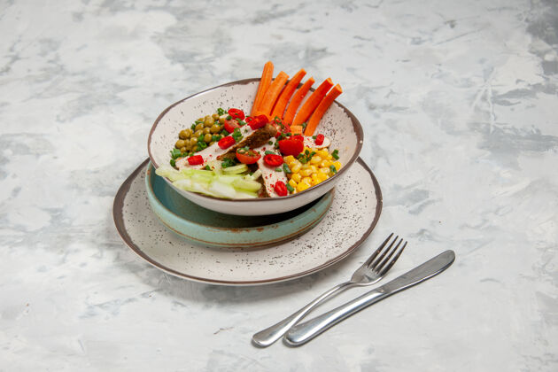 各种美味沙拉的正面图 各种配料放在托盘上的盘子上 餐具放在白色表面 有自由空间盘子饮食配料