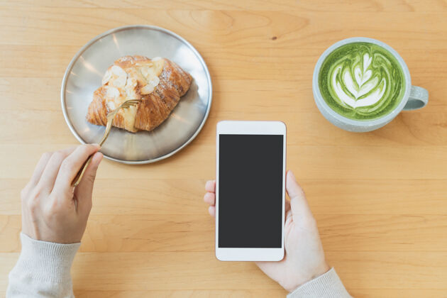 咖啡馆一个女人的手平躺着用手机喝一杯绿茶拿铁电话艺术自助餐厅
