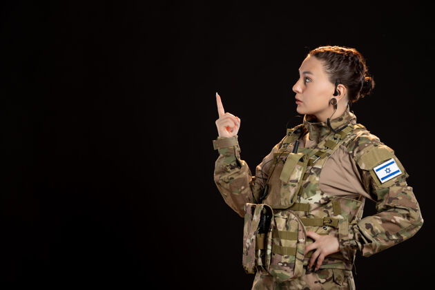 女性黑墙上穿迷彩服的女兵肖像制服战争