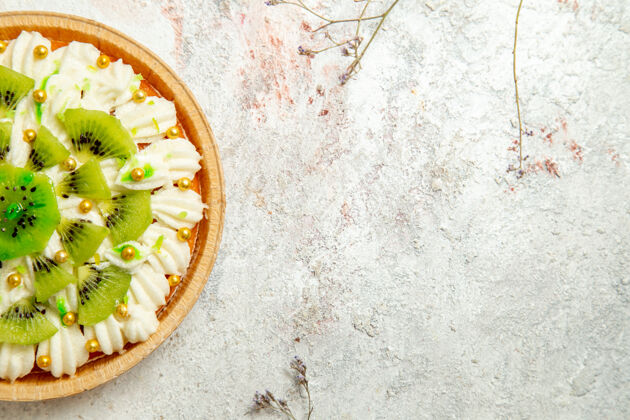 表面俯瞰美味的猕猴桃甜点 白色奶油和切片水果 甜点背景为白色奶油水果好吃的沙子蛋糕