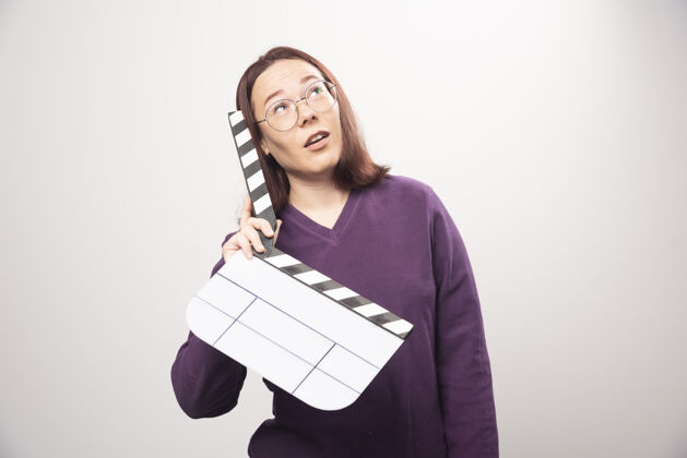 女性一个年轻的女人在一张白色的照片上摆着一个电影院的带子高质量的照片模型镜头女人