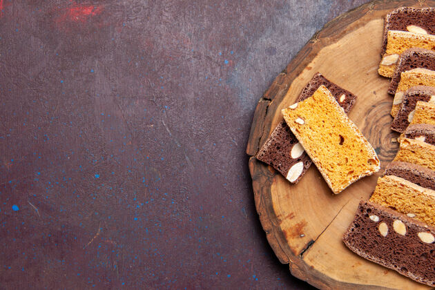 面包俯视美味蛋糕片与坚果的深色背景茶糖饼干饼干蛋糕甜馅饼食物视图美味蛋糕片