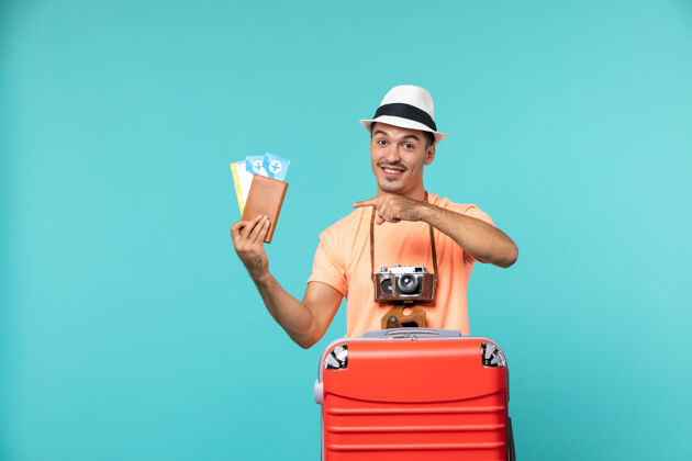 旅行正面图：男人在度假 手里拿着他的票 脸上挂着蓝色的微笑蓝色等待旅行