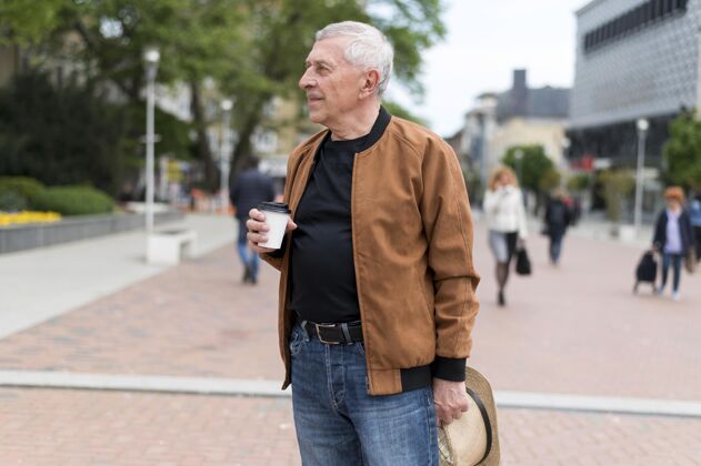 男人中拿咖啡杯户外城市老年人