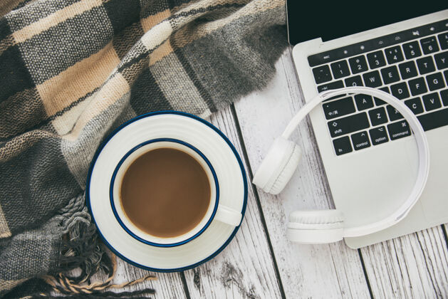 无线一台现代笔记本电脑的顶视图 白色无线耳机 桌上放着一杯咖啡工作美观键盘