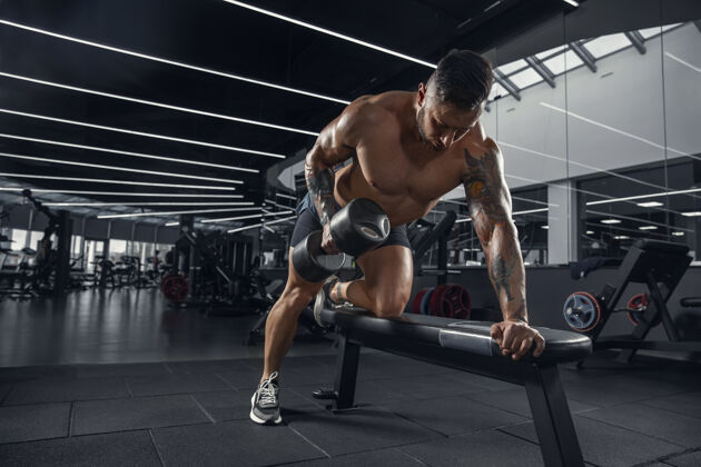 男性年轻的肌肉运动员在健身房练习举重运动活跃锻炼