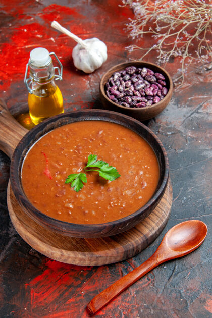 切棕色砧板上的番茄汤和混色桌上的豆子的垂直视图美味健康豆子