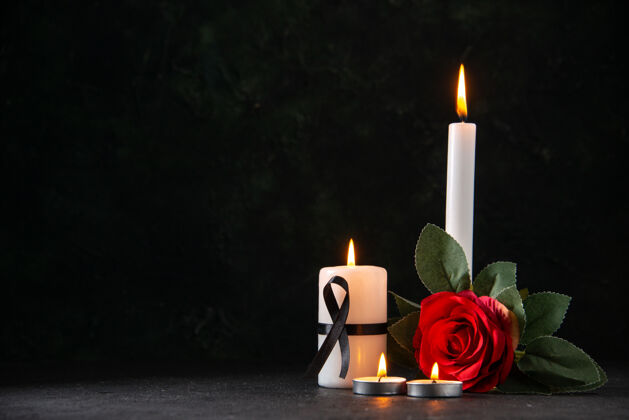黑暗在黑暗的表面燃烧着红花蜡烛的正面图蜡烛火夜
