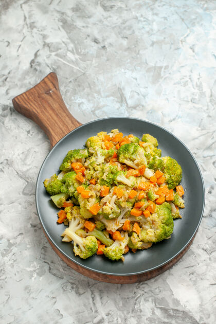 盘子白色背景木质砧板上新鲜健康蔬菜沙拉的垂直视图板沙拉新鲜