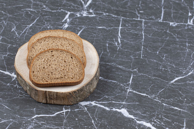 面包房把黑麦面包片放在灰色的木板上健康谷类美味