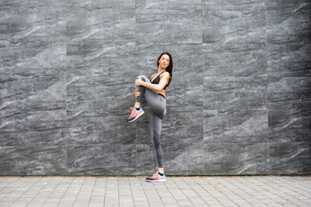 运动运动型年轻女子练习瑜伽锻炼 穿着运动服 户外全长 砖墙健身瑜伽人