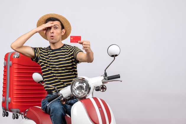骑手推车上戴着草帽拿着信用卡的困惑的年轻人的正视图前面视图稻草