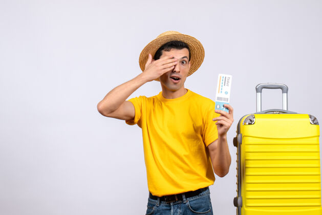 头饰正面图：年轻游客站在黄色手提箱旁 手拿车票遮住眼睛前面手提箱立场
