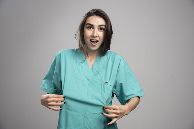 妇女女医生拿着灰色背景的制服高质量的照片年轻人肖像制服