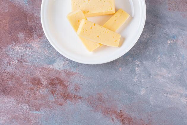 奶酪白色的黄色奶酪片放在大理石表面片好吃切