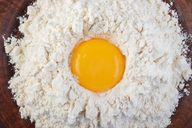 食物把新鲜的生鸡蛋放在石头上未经料理的生的母鸡