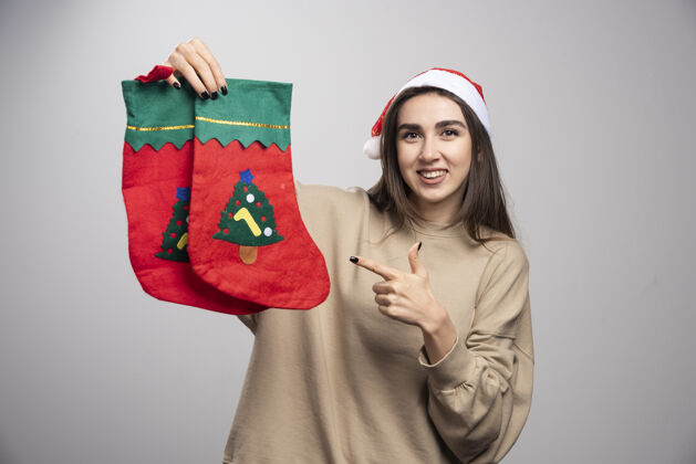女孩戴圣诞帽的小女孩指着两只圣诞袜子惊喜袜子欢呼