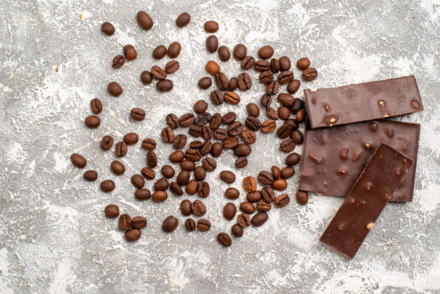 美食白色表面有巧克力条的咖啡籽俯视图食品颗粒