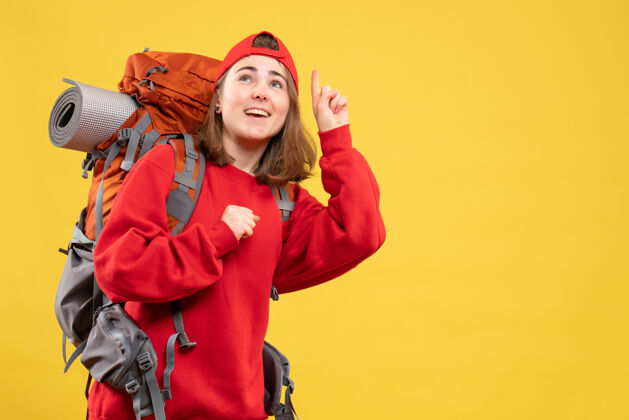 肖像正面图：穿着红色背包的快乐旅行者女士抬头仰望快乐人可爱