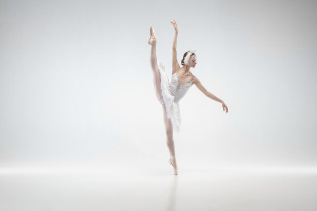 移动动人年轻优雅的经典芭蕾舞演员在白色的工作室背景下跳舞穿着柔软衣服的女人像一只白天鹅优雅 艺术家 动作 动作和运动概念看起来没有重量牛奶灵活运动