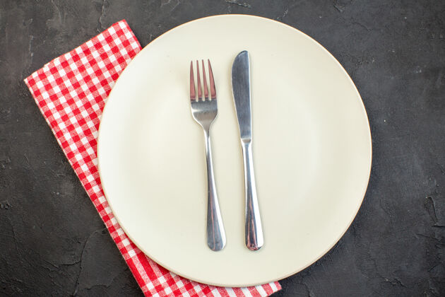 水平顶视图白色板与叉子和刀在黑暗的表面风景白色盘子餐具