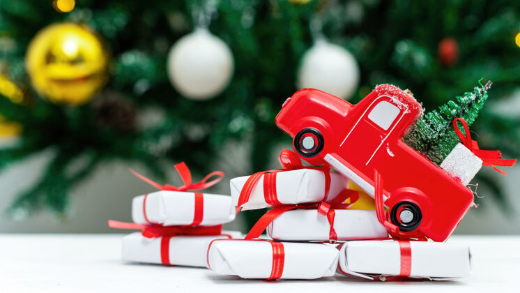 编织红色玩具车 上面有圣诞树 下面有一堆礼物背景是圣诞树有趣欢乐绿色