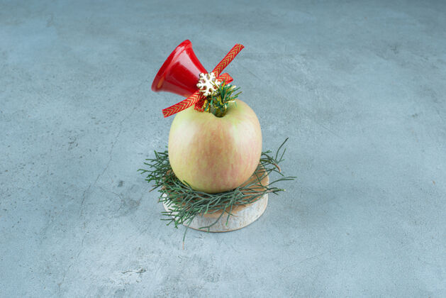 可口一个新鲜的苹果和大理石上的红色圣诞铃铛苹果圣诞节食物