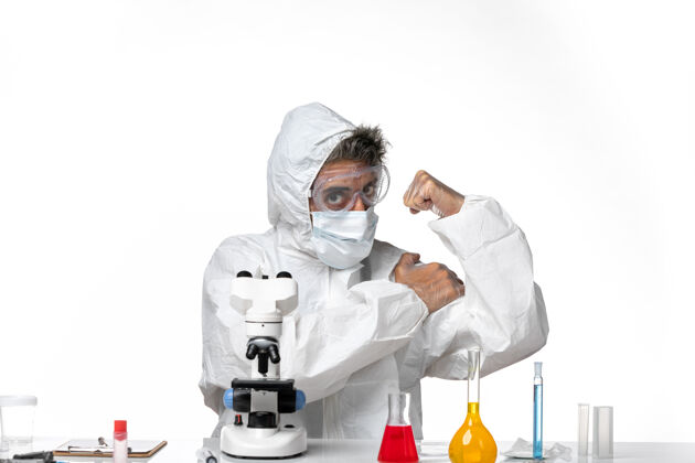 医疗正面图：男医生穿着防护服 戴着口罩 在白色背景下弯曲着大流行的冠状病毒健康病毒外套面罩实验室