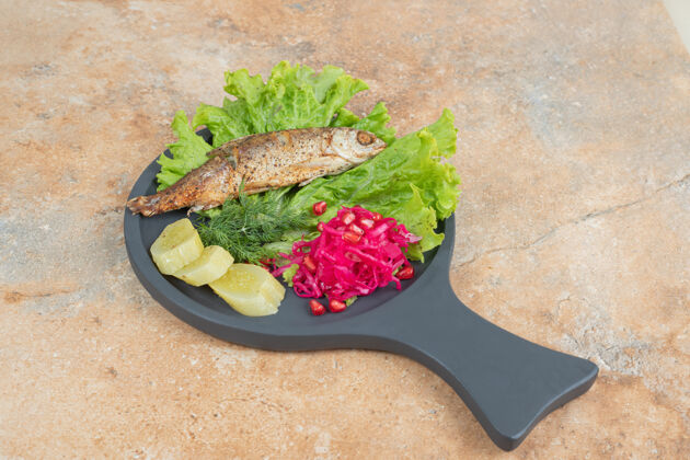 黄瓜青鱼配生菜和红卷心菜在木板上发酵餐海鲜