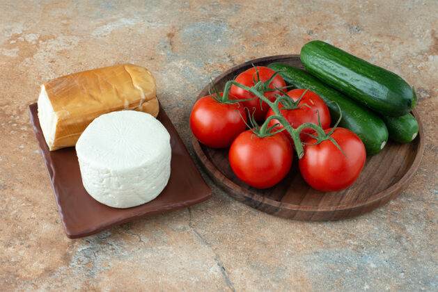 黑黄瓜大理石桌上放着西红柿黄瓜和奶酪奶酪可口食物