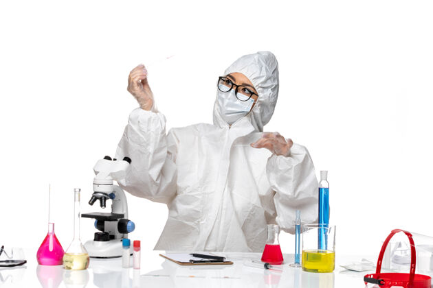 化学正面图：穿着特殊防护服的女化学家在一个浅白色的办公桌上工作医生视图女化学家
