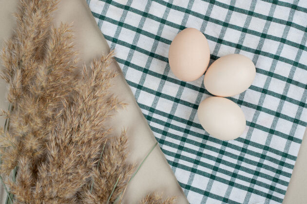 鸡桌布上放三个新鲜的鸡蛋三生的蛋