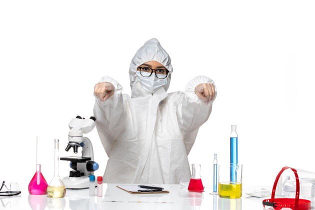 人前视图穿着特殊防护服的女化学家在白色背景上指出化学病毒实验室实验室外套医生医学