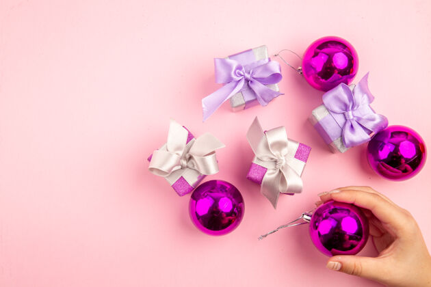 宝石顶视图的小礼物与圣诞树玩具在粉红色的表面新的艺术玩具