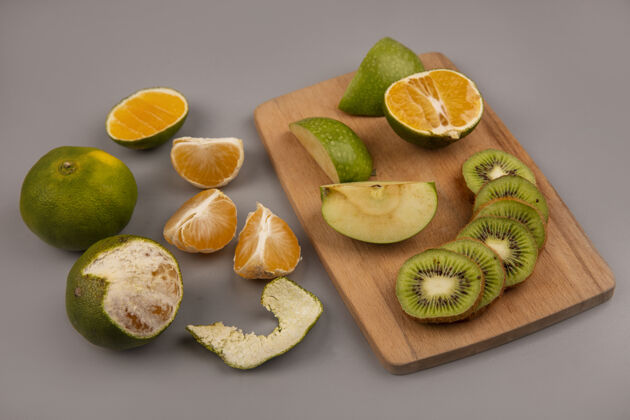 顶部顶视图绿色苹果与猕猴桃片上的木制厨房板与橘子隔离水果灰色食物