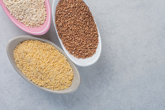 谷类三碗米饭 小麦和荞麦在大理石表面配料面粉小麦