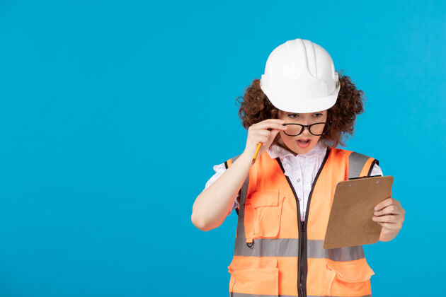 女建设者前视图穿着制服的女建筑工人 蓝色上有注释表情工程师制服