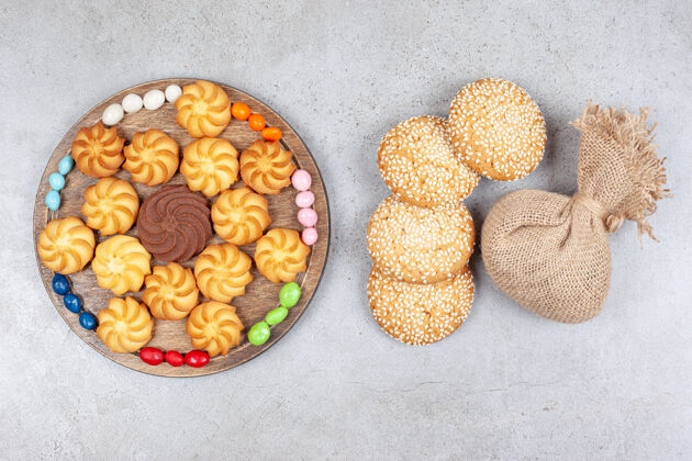 味道饼干和糖果放在木板上 旁边是饼干和大理石背景上的袋子高质量的照片糖饼干零食