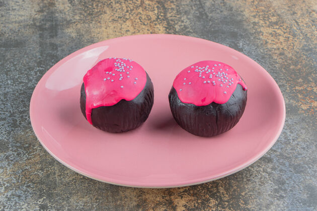 蛋糕两个甜甜的巧克力甜甜圈 上面撒着粉色的糖霜和花洒面团糖美味