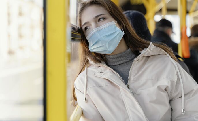 外科口罩带着口罩坐城市巴轻女子城市公共汽车城市病毒
