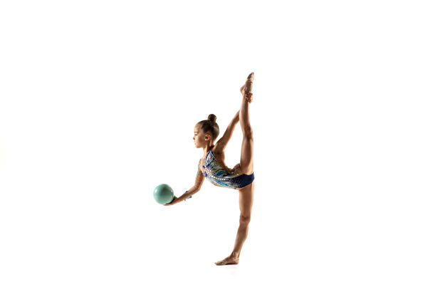 女孩一个柔韧的小女孩被隔离在白色的墙上穿着鲜艳的紧身衣的艺术体操艺术家的小女模优雅的动作 动作和运动用球做练习人类力量体操