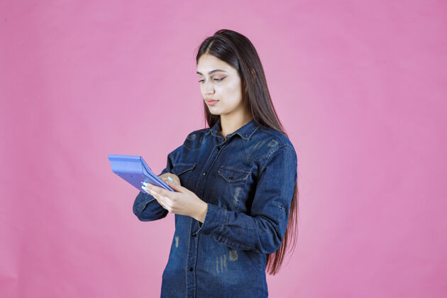 成人女孩手里拿着一个蓝色的计算器在计算会计姿势收入