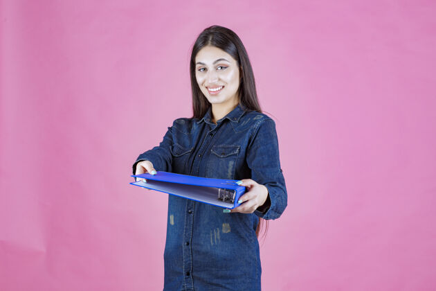 报告女商人拿着一个蓝色的文件夹 把它送给她的同事人分享助理
