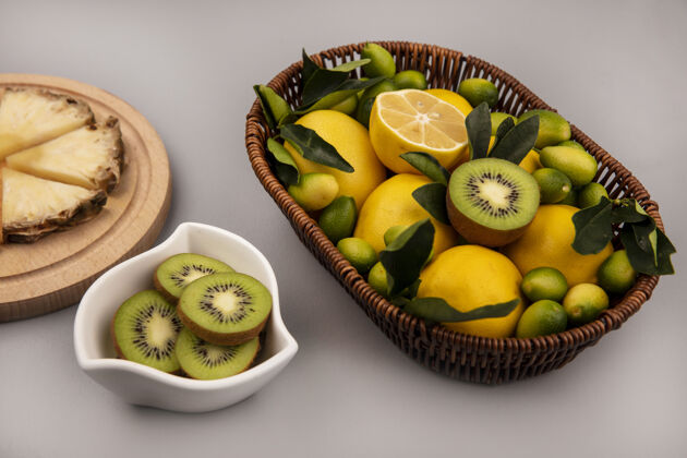 顶部有机水果的顶视图 如猕猴桃金盏花和柠檬在桶上 猕猴桃片放在灰色背景的碗上食物金盏花桶