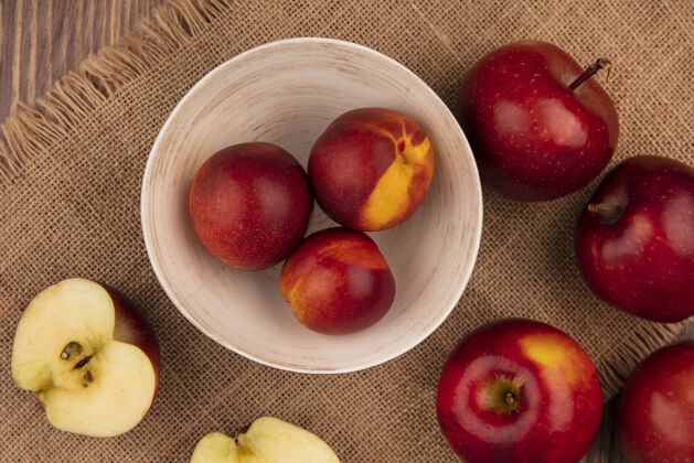 水果顶视图新鲜的桃子在一个袋子布碗与苹果隔离在一个木制的背景苹果桃衣服