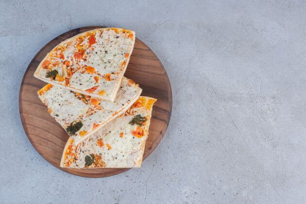 餐盘在大理石背景的木板上做比萨饼片垃圾食品奶酪果皮