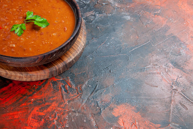 蔬菜在一张混色桌子上的棕色砧板上放半杯番茄汤饭汤晚餐