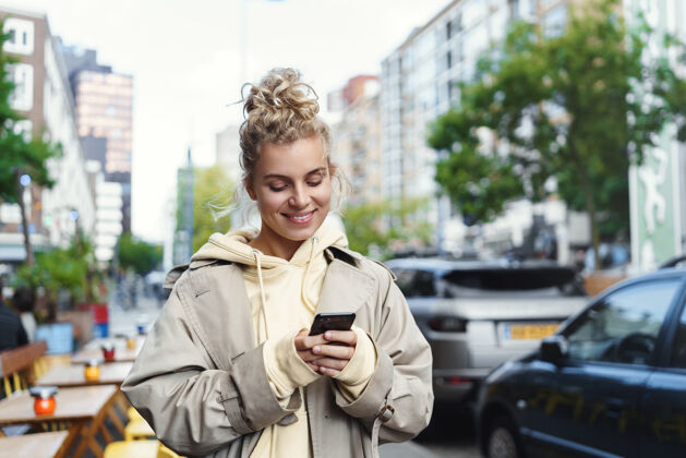 设备微笑美丽的金发女孩用手机漫步女孩手机