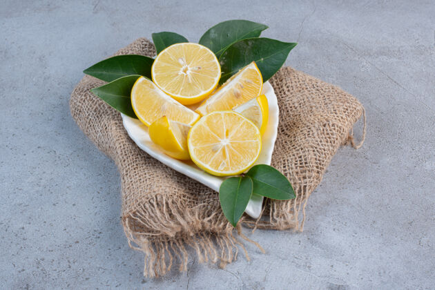 配料一盘柠檬片放在一块布上 背景是大理石健康营养水果